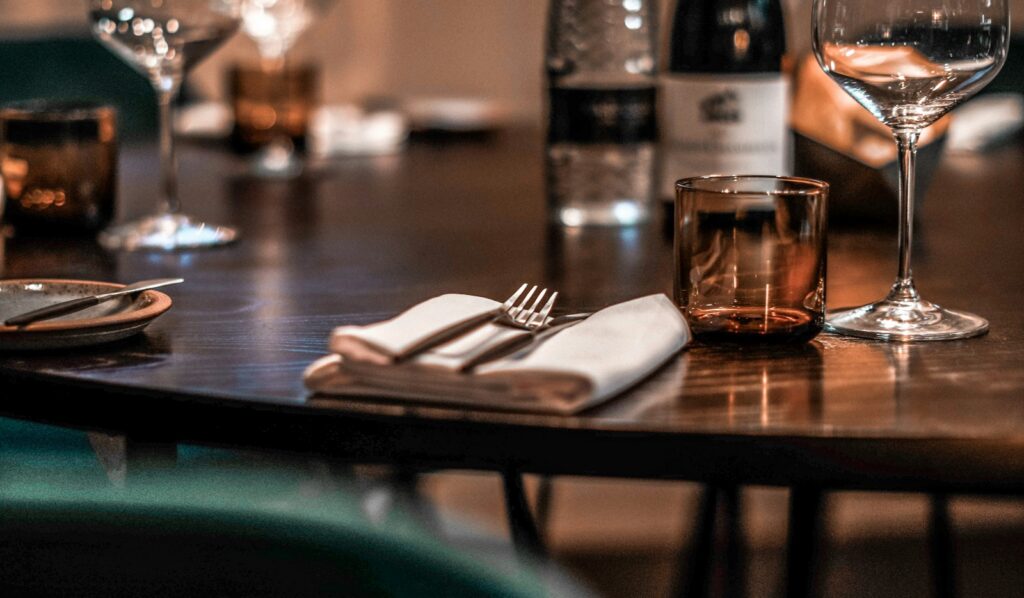 LPM restaurant Dubai — an elegant table setting with wine glasses in a warm, intimate dining room