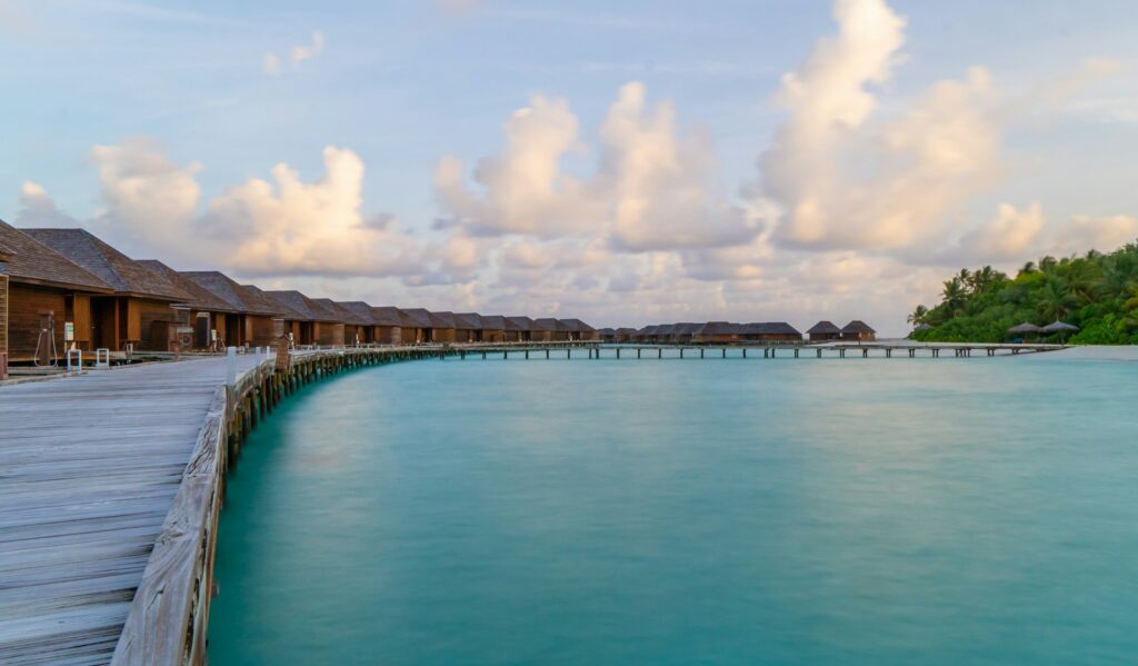 Luxury beach resorts — overwater villas along a jetty above a turquoise lagoon