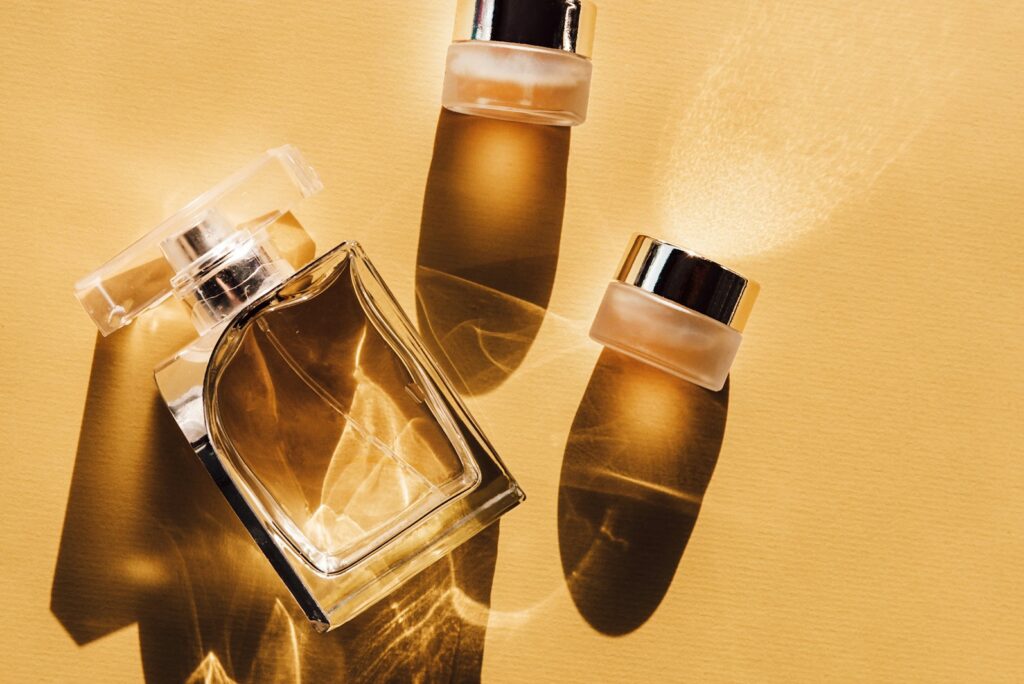 Crystal perfume bottle and two small vials catching warm golden light.