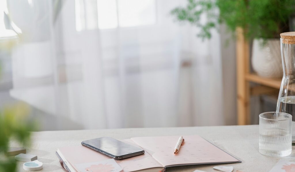 Luxury concierge membership — a phone and notebook on a calm breakfast table by a window