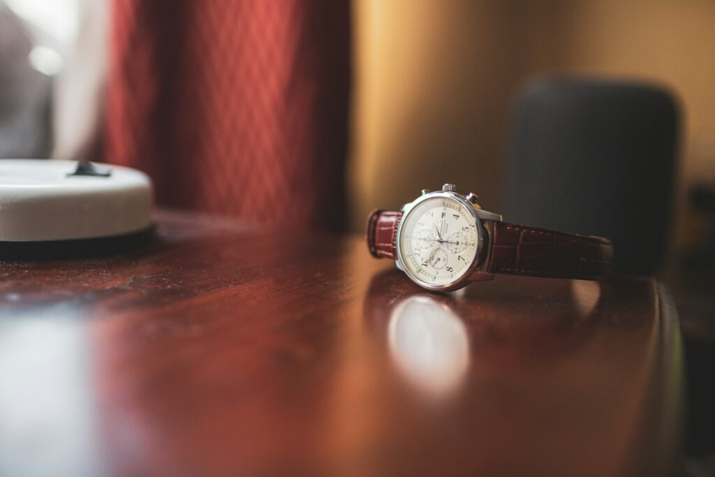 A classic wristwatch on a polished wood desk