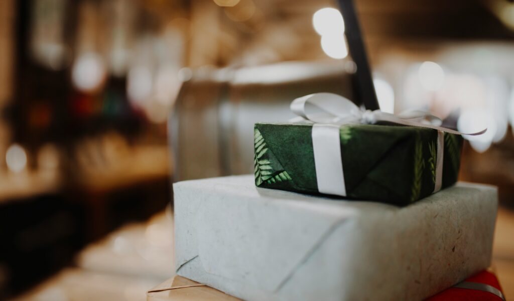 Luxury corporate gifts — hand-wrapped client gifts in green and soft grey paper with a satin ribbon | Perfect.Live