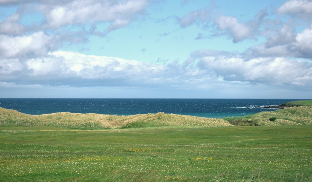 Luxury golf courses — links fairway with grassy dunes beside the sea