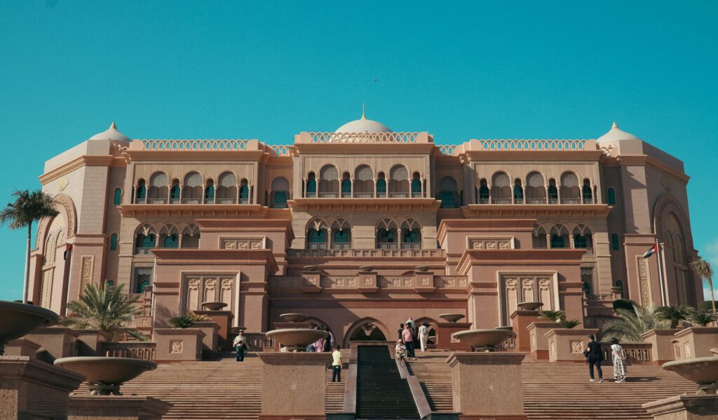 Emirates Palace, one of the luxury hotels Abu Dhabi is known for, seen from its entrance steps under a clear blue sky