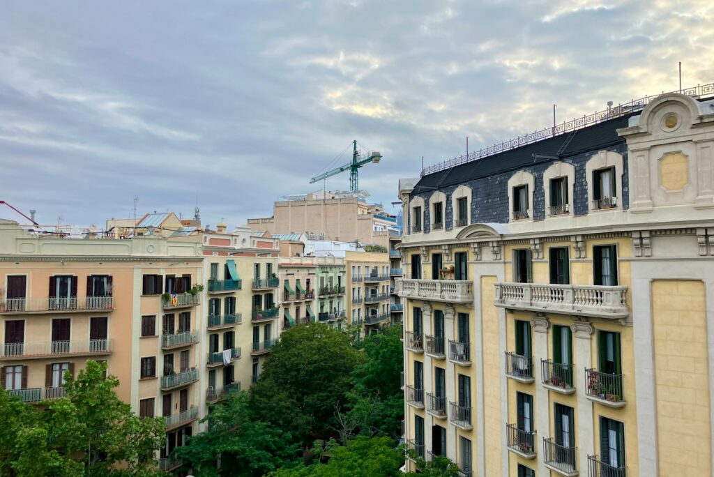 Residential buildings with balconies and green trees on a Barcelona city street