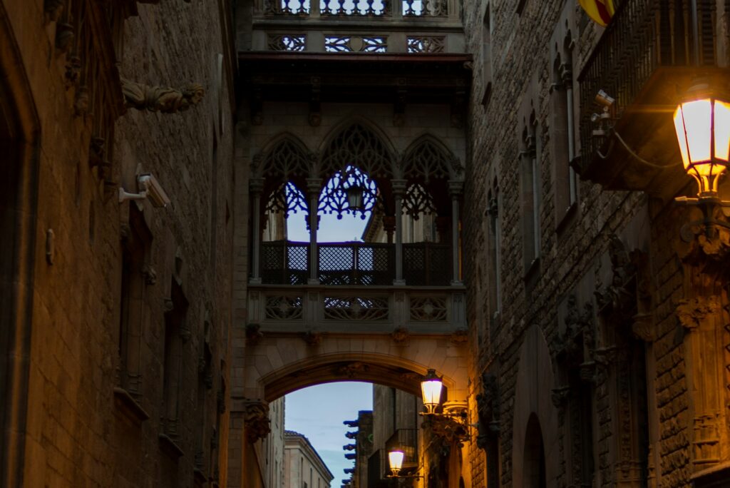 Narrow alley with a stone bridge overhead in the Gothic Quarter of Barcelona