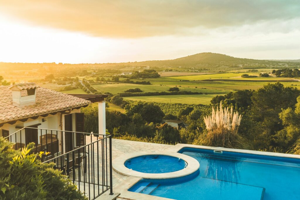 Villa pool and terrace looking over green countryside at sunset in Mallorca
