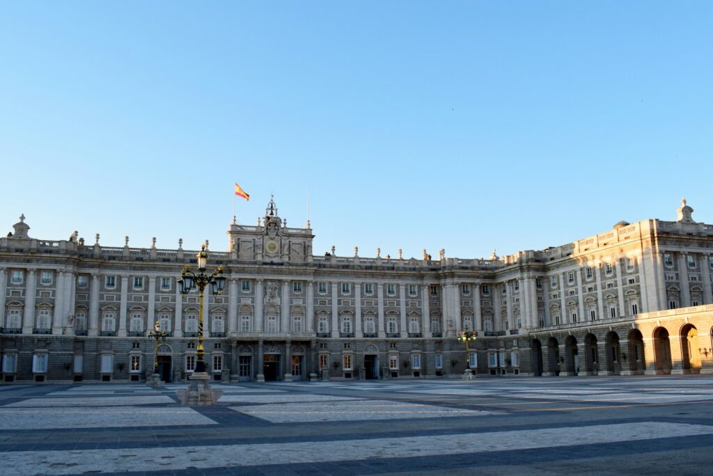 The long facade of the Palacio Real in Madrid under a clear blue sky