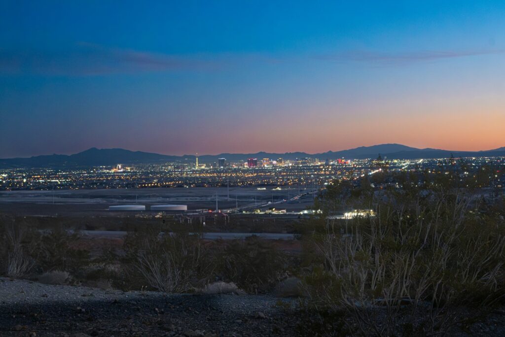 Las Vegas city lights under a twilight sky with mountains beyond