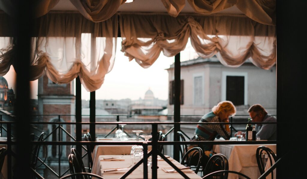 Terrace table at dusk overlooking the rooftops of Rome, the setting of Michelin star restaurants Rome