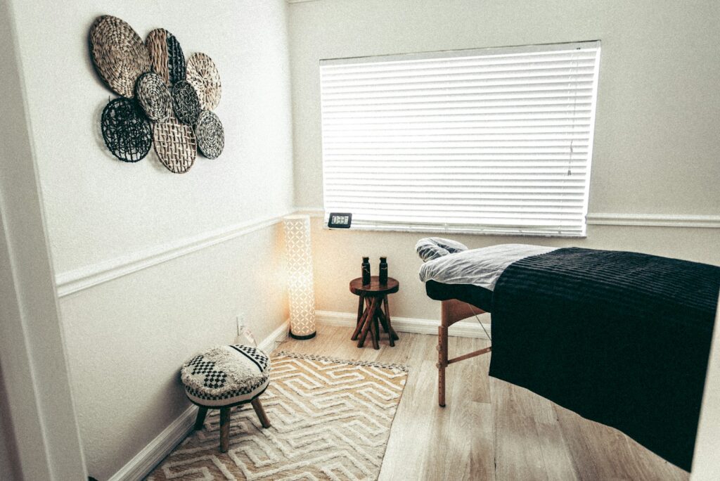 Quiet treatment room with a couch, a floor lamp, and woven wall decor in soft daylight