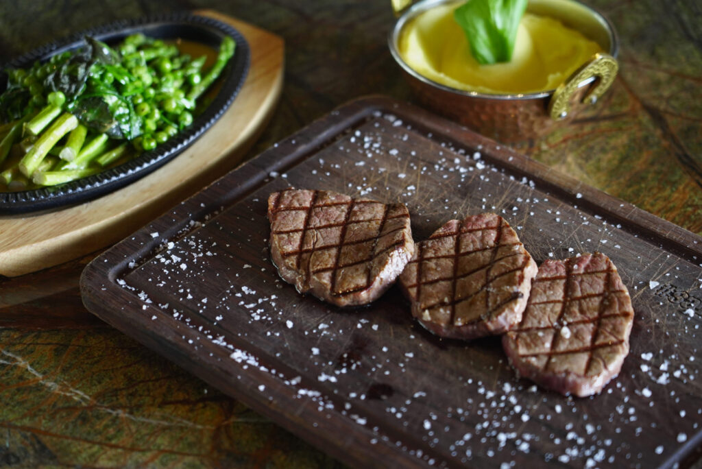 Grilled steak with sea salt on a wooden board at Nusr-Et Dubai