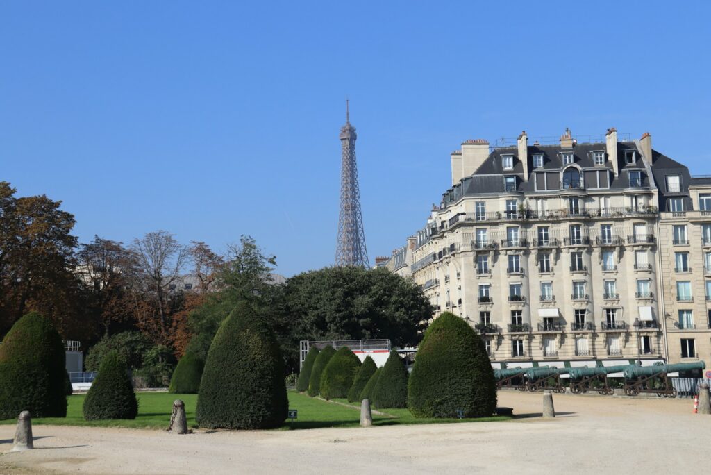 Parisian apartment building with the Eiffel Tower rising above a garden