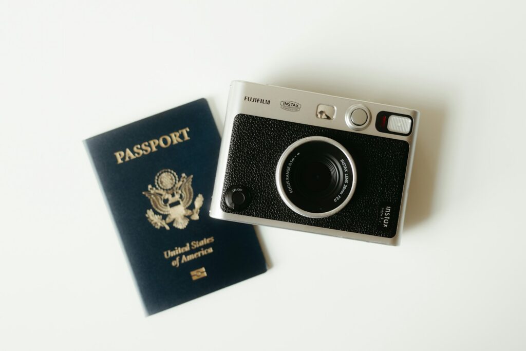 A passport and vintage camera laid out for a trip