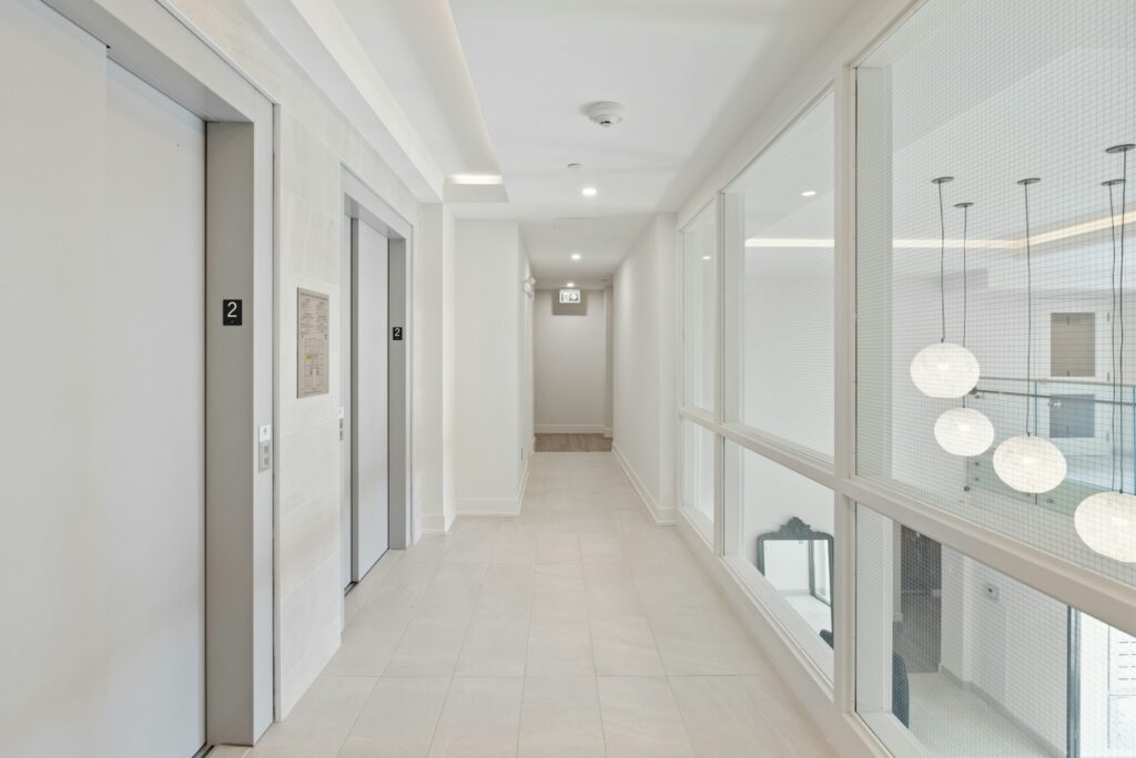 Light, uncluttered corridor with glass partitions and pale flooring