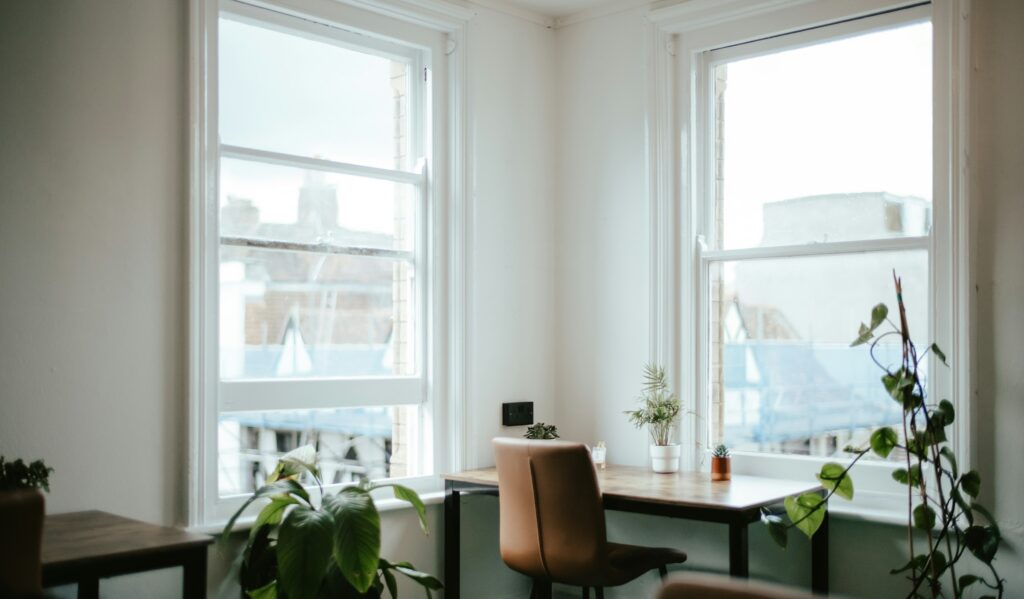 Private health screening room: a bright, quiet consulting space with a desk beside tall sash windows