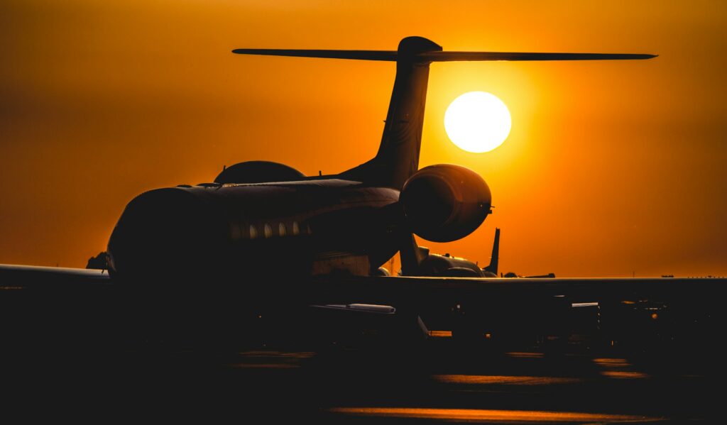 Private jet silhouetted against a low sun on a quiet apron at dusk, illustrating private jet membership