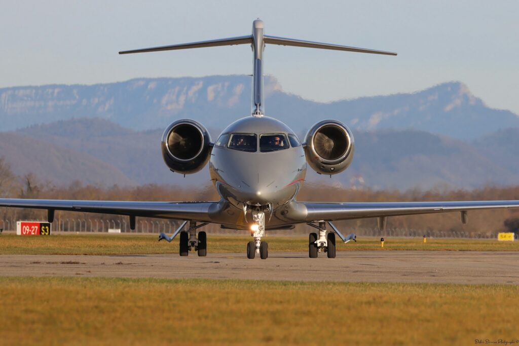 A private jet on the runway with mountains in the background