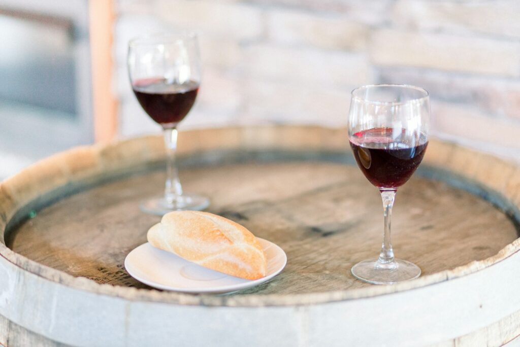 Two glasses of red wine on an oak barrel table