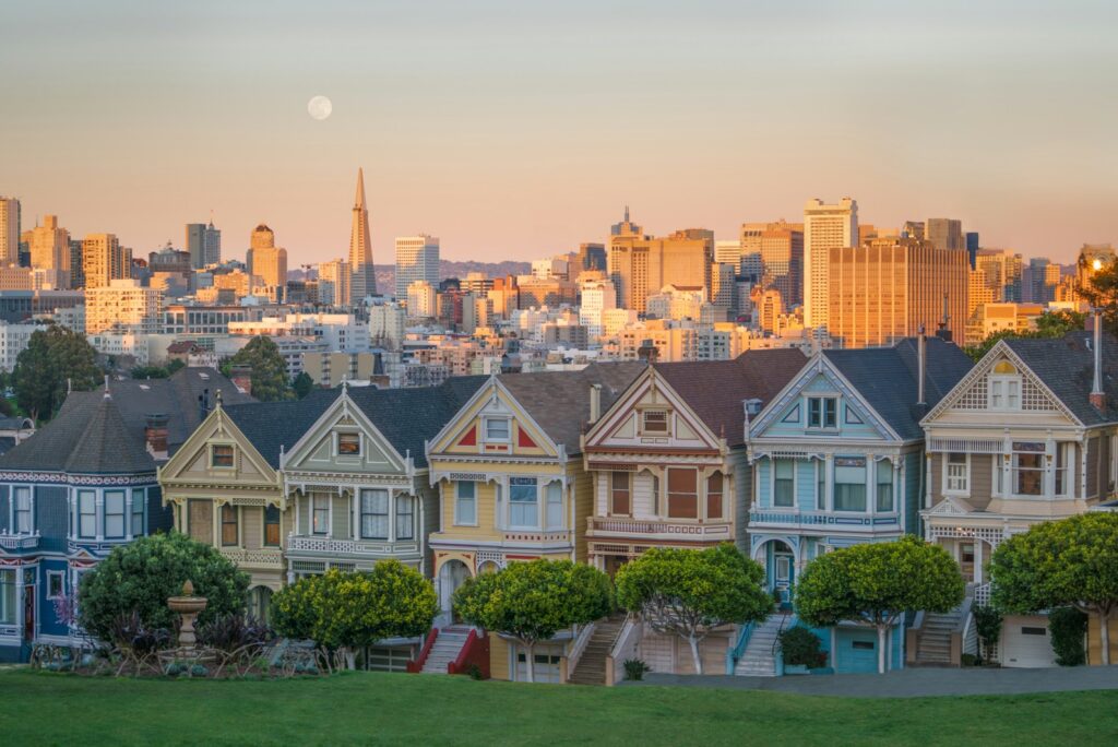 The Painted Ladies Victorian houses with the San Francisco skyline behind at dusk
