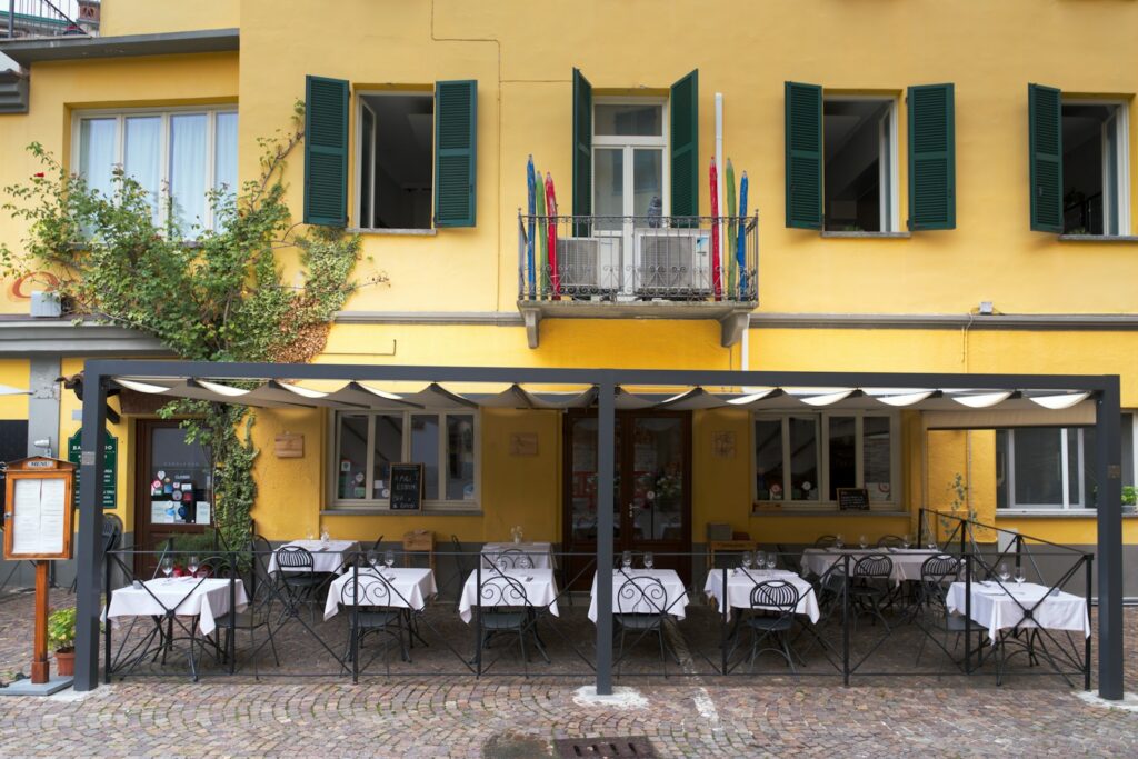 Restaurant terrace set for evening dining with white tablecloths