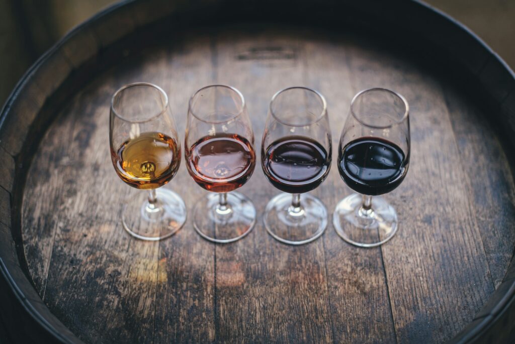 Flight of four wines in tasting glasses on a wine barrel