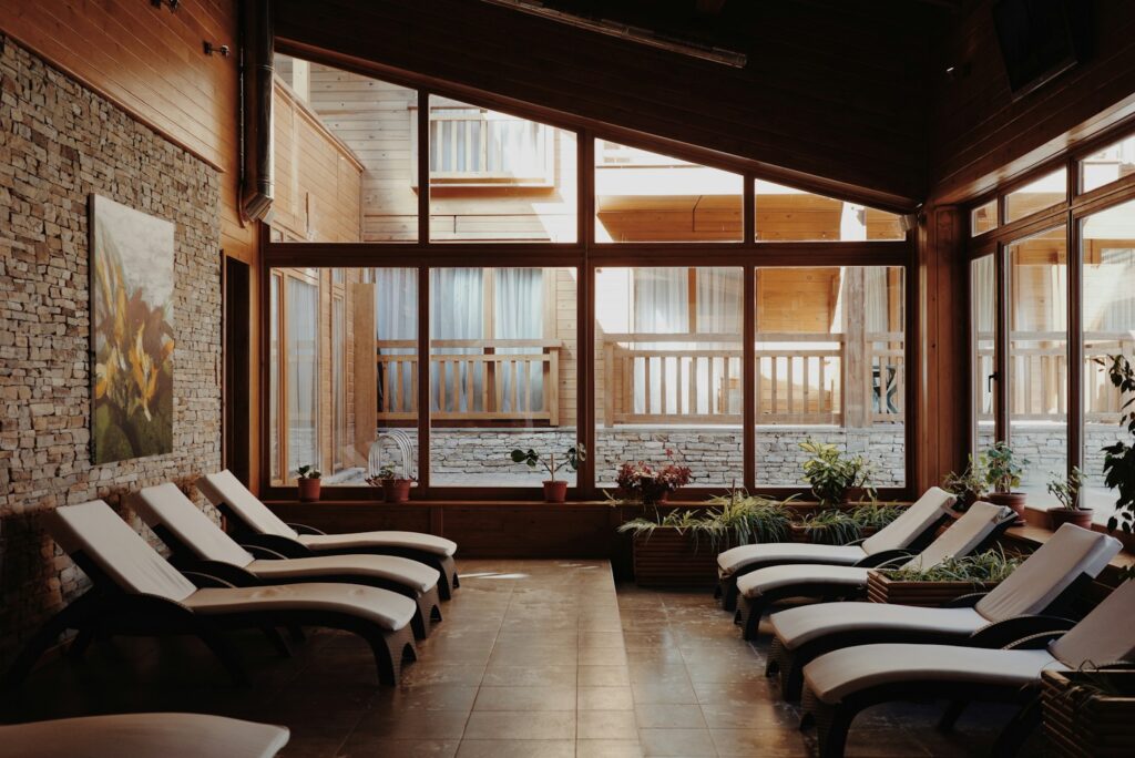 Relaxation loungers in a sunlit spa room with tall windows