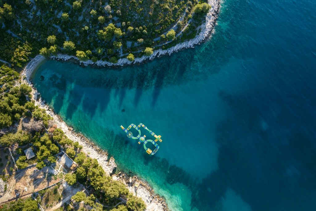 Aerial view of a boat in a turquoise cove on the Dalmatian coast near Čiovo